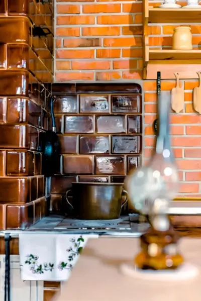 Kaflowy piec i ceglana ściana — dom z bali wynajem