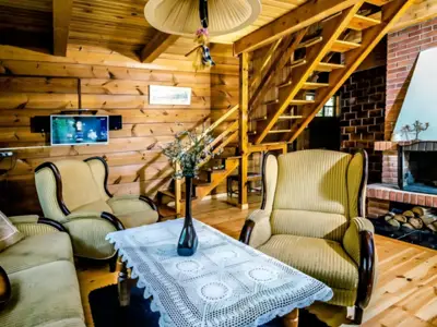 Salon z fotelami i schodami — domek w lesie Supraśl