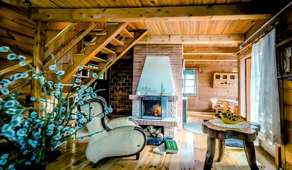 In The Woods Supraśl — salon z kominkiem i drewnianymi schodami