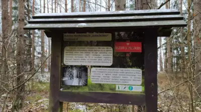 Tablica rezerwatu — domek w lesie przy rezerwacie przyrody
